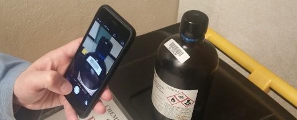 Image of cell phone taking a picture of barcode on chemical bottle.