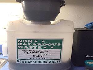 Figure 1 – Waste collection container for extracted teeth containing amalgam in CDM Clinic; container is managed by EH&S Waste collection container for extracted teeth containing amalgam in CDM Clinic; container is managed by EH&S