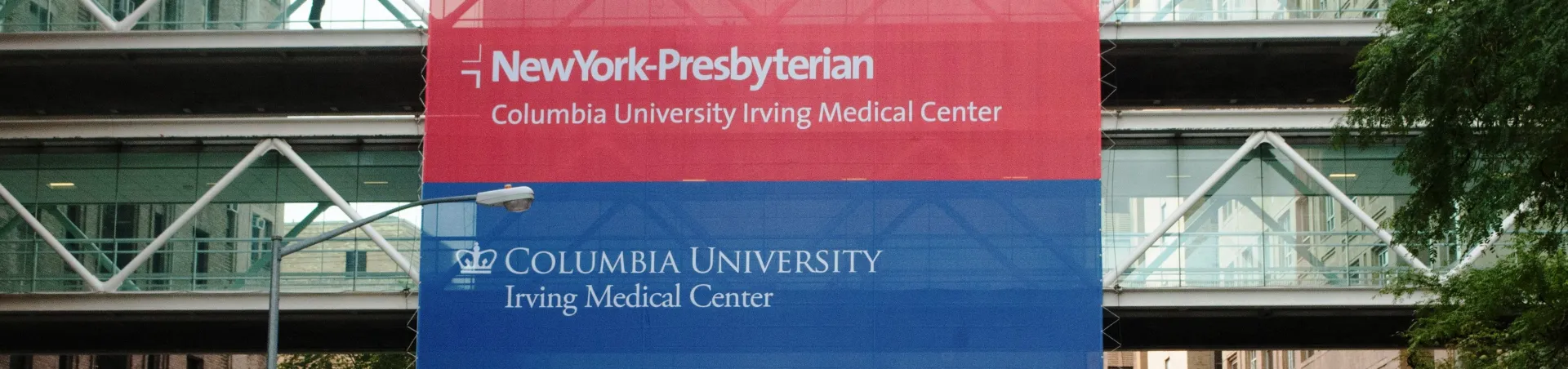 Signs for NYPH and CUMC hanging from buidling skywalk